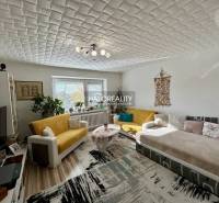 Nappali egy kétszobás lakásban, fa mintázatú padlóval és kényelmes ülőgarnitúrával.