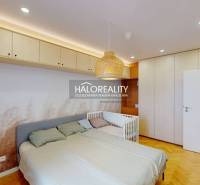 Hálószoba egy háromszobás lakásban beépített szekrényekkel, ággyal és kisággyal.