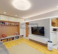 Nappali egy háromszobás lakásban, fa dekorációjú padlóval és beépített tárolóhellyel.