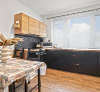 Konyha egy háromszobás lakásban világos dekorációval és fa mintázatú padlóval.