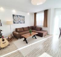 Nappali egy családi házban nagy kanapéval és fa dekorációjú padlóval.