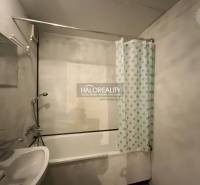 Fürdőszoba egy háromszobás lakásban káddal és kék pöttyös függönnyel.