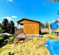 Faház Partizánskomban, amelyet természet vesz körül, füves területtel és kinti ülőhellyel.