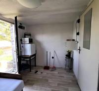 Chata belseje háztartási gépekkel, kanapéval és kilátással a kinti természetre.