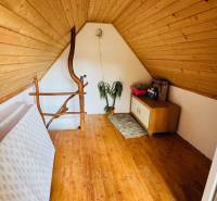 Padlástér fa dekorációjú padlóval és egyszerű bútorokkal egy faházban.