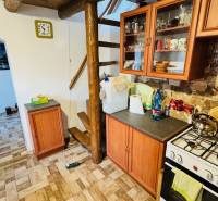 Konyha faházban fa dekorációval, lépcsőkkel, készülékekkel és bútorokkal, kőfallal.