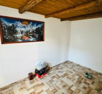 Nappali egy faházban fa mennyezettel, fa dekorációjú padlóval és képpel a falon.