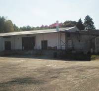 Raktárak és csarnokok a Nagykürtösi Vasút utcában fákkal körülvéve.