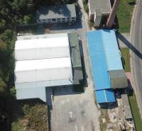 Légi felvétel a csarnokokról és raktárakról a Vasút utca közelében, zöldövezet és földterület által körülvéve.