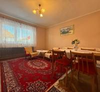 Nappali családi házban szőnyeggel, fa bútorokkal és fa dekorációjú padlóval.