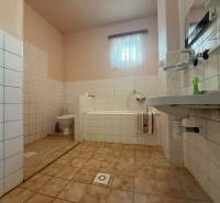 Fürdőszoba káddal és mosdóval egy családi házban, csempével és világos falakkal.