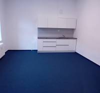 Irodák fehér szekrényekkel és kék szőnyeggel a Františkánskej utcában, Nagyszombatban.