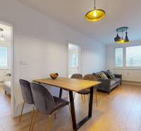 3 szobás lakás belső tere fa dekor padlóval, étkezőasztallal és kanapéval.