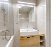 Fürdőszoba káddal, mosdóval és tükörrel egy háromszobás lakásban. Elegáns dizájn.