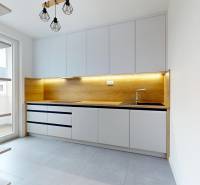 Konyha egy háromszobás lakásban fa dekorációval és világos berendezéssel.