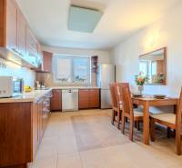 Konyha egy kétszobás lakásban fa dekorációval és étkezőasztallal.