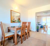 Világos étkező faasztallal egy kétszobás lakásban, fa mintázatú padlóval.