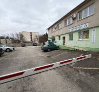 Kereskedelmi helyiségek a szenicei Štefánik utcában, épület előtti parkolóval.