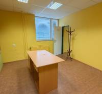 Sárga falak az irodában fa bútorokkal, fa mintás padló, fogas.