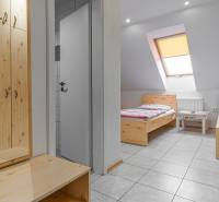 Szállodai és panziós szoba belső tere két ággyal és szekrénnyel, fa dekorációjú padlóval.