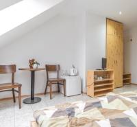 Szoba szállodában és panziókban két székkel, asztallal, szekrénnyel és ággyal.