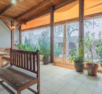 Napos helyiség fából készült ülőalkalmatosságokkal a szállodákban és panziókban, növényekkel körülvéve.