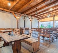 Fa asztalok és padok a belső térben, szállodák és panziók fa dekorációjú padlóval.