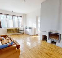 Nappali tér kanapéval, kandallóval és fa dekorációjú padlóval családi házban.