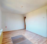 Szoba egy családi házban, fa dekorációjú padlóval és nagy ablakokkal.