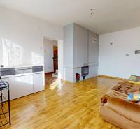 Családi ház nappalija kanapéval és fa dekorációjú padlóval.