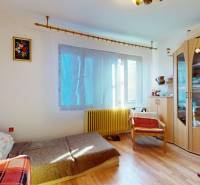 Szoba egy családi házban fa dekoros padlóval, kanapéval és szekrénnyel.