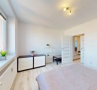 Világos hálószoba egy háromszobás lakásban, fa dekoros padlóval és minimalista berendezéssel.