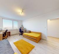 Világos szoba két ággyal, íróasztallal és fa dekorációjú padlóval egy háromszobás lakásban.