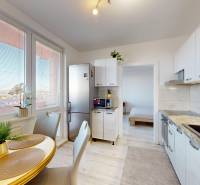 Konyha egy háromszobás lakásban étkezőasztallal, fa dekoros padlóval és nagy ablakokkal.