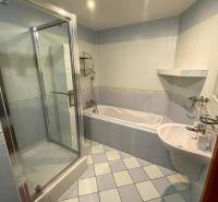 Fürdőszoba egy háromszobás lakásban zuhanyzóval, káddal és világos csempével.