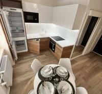 Konyha egy kétszobás lakásban fa dekorációjú padlóval és étkezőasztallal.