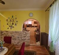 Ebédlő egy családi házban, boltíves átjáróval és fa dekorációjú padlóval.