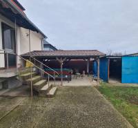 Családi ház Ógyallán tágas udvarral, előtetővel és külső lépcsőkkel.