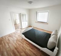 Világos szoba ággyal, fa dekorációjú padlóval, családi házban.