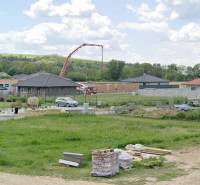 Telkek - lakóhely Modrovkán; láthatóak félkész házak és építőanyagok.