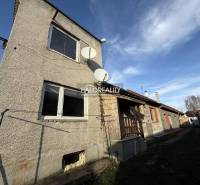 Családi ház Chynoranyban műholdakkal és kerttel, mellette további házak.