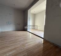 Szoba családi házban, fa mintázatú padlóval és egyszerű falakkal.