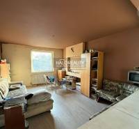 Nappali kanapéval, bútorokkal és konyhasarokkal egy családi házban.