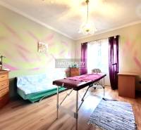 Szoba családi házban masszázsággyal és fa dekorációjú padlóval.