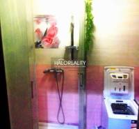 Fürdőszoba egy kétszobás lakásban zuhanyzóval és mosógéppel, rózsaszín árnyalatokkal.