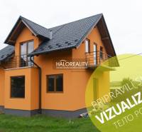 Narancssárga családi ház Sady nad Torysou-ban ferde tetővel és külső erkéllyel.