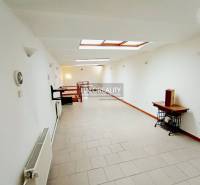 Világos folyosó egy családi házban fehér falakkal és tetőablakokkal.