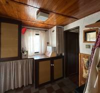 Családi ház belső tere fa mennyezettel és függönyökkel, hangulatos sarok dekorációs elemekkel.