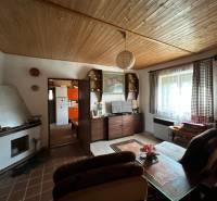 Nappali egy családi házban fa dekorációval a mennyezeten és otthonos bútorokkal.