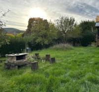 A családi ház kertje Kalšán, kandallóval és háttérben zölddel.